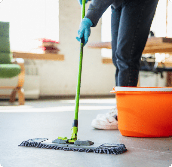 School cleaning staff mopping a hallway floor with a bucket and mop.